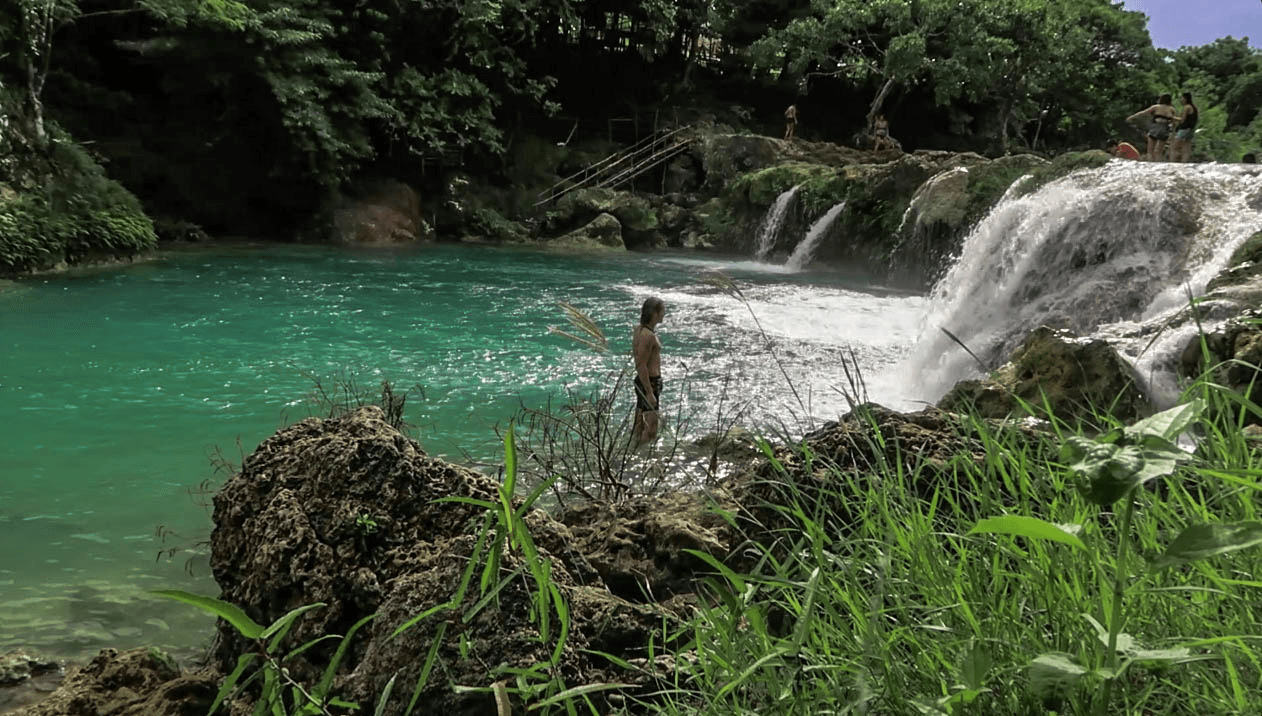lenny through paradise standing in the water at bolinao falls waterfall two in pangasinan province philippines